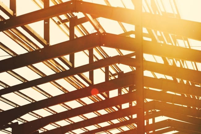 Timber roof framing of a house under construction at sunset